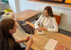 Dr. Diana Lolea discută cu un pacient în timpul unei consultații de diabetologie și completează o recomandare medicală.